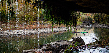paddlers as viewed through a waterfall