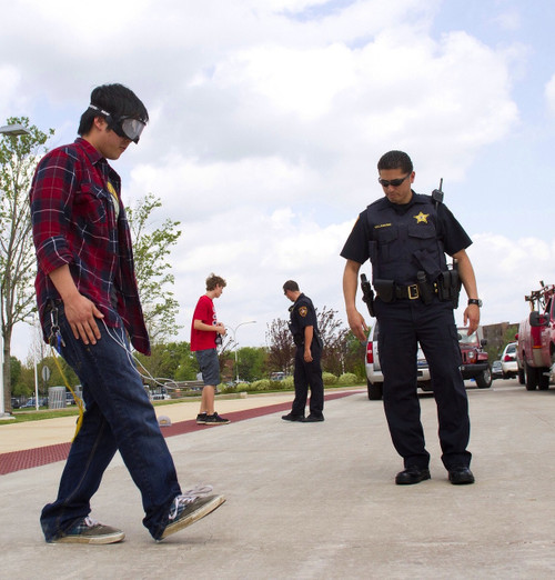 Performing a one legged-stand test which is a field sobriety test while wearing a Drunk Busters Impairment Goggle.