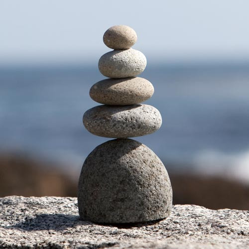 Quintuple rock cairn of five weathered stones stacked in decreasing size