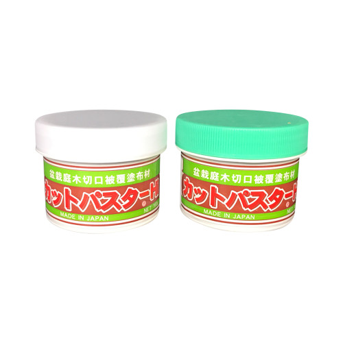 An image of two jars of Japanese bonsai cut paste side-by-side against a plain white background. Both containers feature a label with a red center band, green top and bottom borders, and bold white Japanese characters. The words "MADE IN JAPAN" are printed in white on the lower green band of both jars. The jar on the left has a smooth white plastic lid, while the jar on the right features a light green lid with a ribbed texture along the side. This bonsai cut paste kit is used as a wound sealant after pruning to protect trees from infection and promote faster healing.