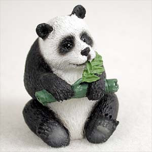 Miniature panda figurine sitting upright with textured fur, a bonsai accessory