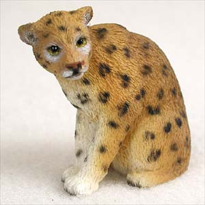 A detailed miniature figurine of a leopard cub, perfectly sized for decorating a bonsai tree or terrarium. The leopard is captured in a seated pose with its head tilted slightly, giving it a gentle and curious look. Its coat is a warm golden-brown color, covered with realistic dark spots, while its paws and muzzle are a soft white. The surface of the figurine is finely textured to resemble short fur, adding a touch of nature-inspired realism to any miniature landscape or bonsai arrangement.
