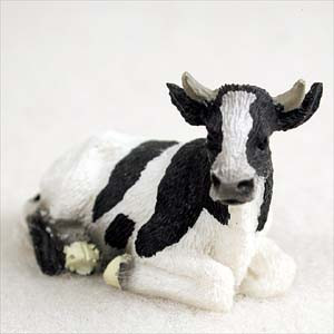 Miniature Holstein bull figurine lying at rest, a decorative bonsai accessory