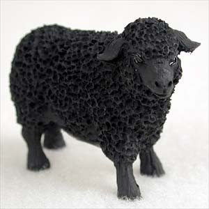 A miniature black sheep figurine intended as a decorative accent for bonsai tree displays. The figurine is depicted in a standing position, completely finished in a uniform matte black color. Its wool is characterized by a distinctive, deeply textured, and porous surface, while the face and legs have a smoother finish with fine details. This small-scale animal figure is ideal for creating a miniature pastoral scene within a container garden or bonsai arrangement.
