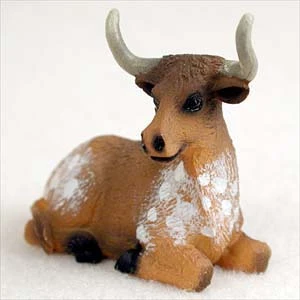 Miniature longhorn steer figurine lying at rest, a decorative bonsai accessory