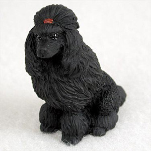 A detailed miniature black poodle figurine designed as an accent for bonsai trees and indoor gardens. The small sculpture depicts a black poodle sitting in an upright, attentive pose. It features intricately molded fur that mimics long, wavy locks, particularly on its drooping ears and chest. A distinctive top-knot is gathered on its head, secured with a small red bow. The poodle has a refined muzzle with a black nose and small, glinting eyes. This decorative accessory is shown against a neutral white background, emphasizing its detailed craftsmanship and dark, solid color.