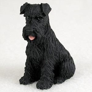 Miniature solid black Schnauzer figurine with uncropped ears, in a seated pose
