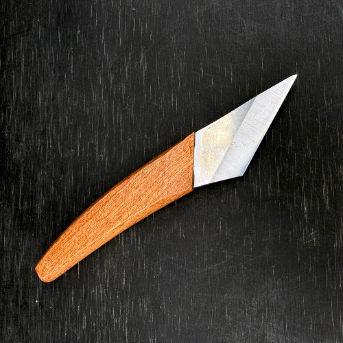 A top-down studio photograph features a professional right-hand bonsai grafting knife, model GFN-03, resting diagonally on a dark, textured charcoal-colored surface. The precision tool consists of a smooth, light-brown wooden handle with a rich, natural grain and a slightly curved, ergonomic shape designed for a comfortable grip. 

Secured into the handle is a high-quality steel blade, uniquely crafted for grafting with a single-sided bevel that tapers to a fine, acute point. The metallic surface of the blade shows a clean, brushed finish, catching the light to highlight its sharp cutting edge. This specialized knife is an essential tool for bonsai enthusiasts, designed to make the clean, delicate, and precise cuts necessary for successful grafting and bark scoring. The contrast between the warm tones of the wood, the cool sheen of the metal, and the matte, linear texture of the background emphasizes the knife's sleek and functional design.