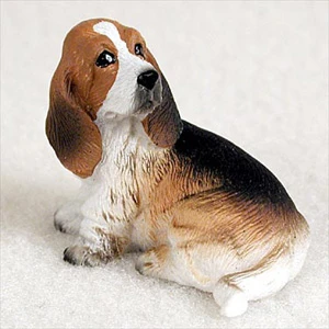 Miniature tricolor Basset Hound figurine sitting and looking upward