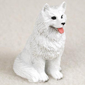 A detailed miniature Samoyed dog figurine, designed as a charming accessory for a bonsai tree arrangement. The small white dog is sculpted in a sitting position, looking slightly upward with an alert and friendly expression. The figurine features a highly textured surface that realistically mimics the dense, fluffy white coat characteristic of the Samoyed breed. Its small black eyes and nose contrast sharply with its pristine white fur, and a tiny pink tongue peeks out from its mouth, giving it a playful appearance. This decorative dog statue is perfect for adding a touch of personality and life when placed at the base of a miniature bonsai scene.