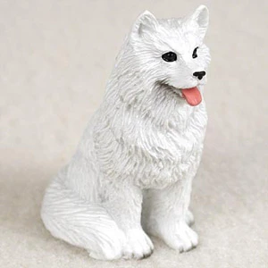 Miniature white Samoyed figurine sculpted in a sitting position, looking upward