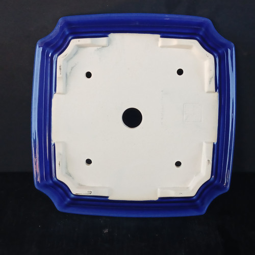 Underside of the 9 inch square Yixing pot on a black background