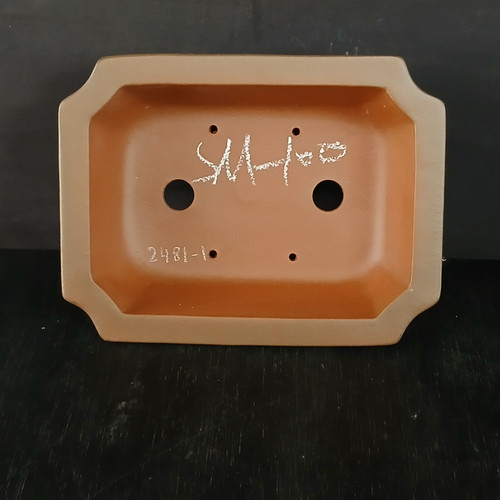 An overhead view looking into the interior of an 8-inch unglazed Yixing ceramic bonsai pot, highlighting its rectangular shape with elegant, notched-in corners. The pot is crafted from a classic reddish-brown terracotta clay with a smooth, matte finish typical of high-quality Yixing pottery. Inside, two large circular drainage holes are centered horizontally, surrounded by four smaller wiring holes used to secure a tree. A white, handwritten artist's signature or mark is prominent in the center, while the specific model number "2481-1" is etched into the bottom-left corner. The pot is displayed on a dark, textured black surface, providing a sharp contrast that emphasizes the earthy, warm tones of the clay.