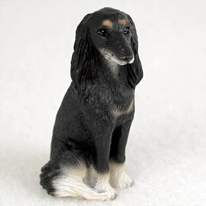 Miniature Saluki figurine in a graceful sitting position, looking to the side