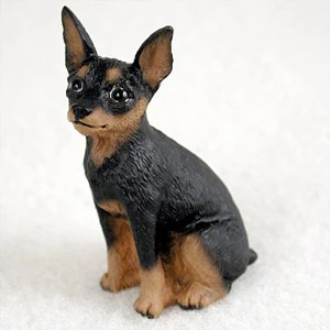 Miniature tan and black Miniature Pinscher figurine in a classic sitting pose