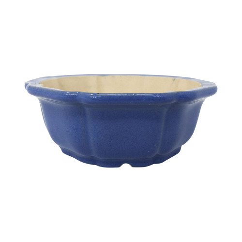 A side view of a 6-inch Yixing ceramic bonsai pot featuring a vibrant cobalt blue glazed exterior. The pot has a traditional scalloped or lobed "mokko" shape, resembling a stylized flower, with a subtly flared rim and vertical ribbing that creates a rhythmic, textured appearance. The interior of the bowl is an unglazed, light beige ceramic. The pot's glossy finish and deep blue color contrast sharply against a clean white background, showcasing the tiered base and small drainage notches at the bottom.