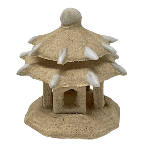 An image of a small, two-tiered Chinese pagoda figurine, isolated against a white background. This miniature architectural piece, designed as a bonsai accessory or garden ornament, is crafted from a light tan material with a coarse, sandy texture that mimics carved stone. The structure sits on a thick, solid base, supporting a central chamber with small arched openings. Two distinct, sloping roof tiers characterize the design, with the lower roof being wider than the top. Both roofs feature several small, white, pointed accents resembling teeth or horns protruding from the eaves. The very top of the pagoda is finished with a small, rounded finial. Its earthy, rustic aesthetic is intended for creating a serene, traditional landscape within a bonsai pot or miniature display.