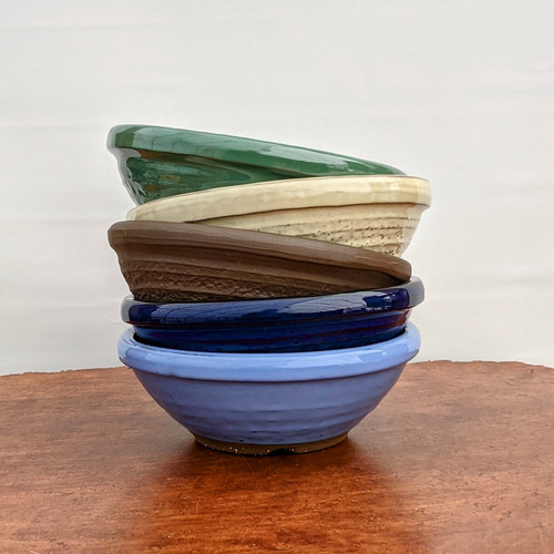 Stack of five small round Japanese bonsai pots in assorted finishes, 8 inch