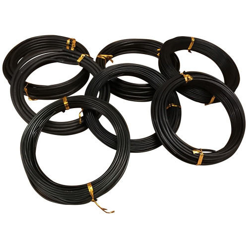 A collection of seven individual 100g rolls of black anodized aluminum bonsai wire is neatly arranged in an overlapping cluster on a plain white surface. Each coil is tightly wound and secured with several small, shiny gold-colored twist ties to keep the wire orderly. The wire has a smooth, matte black finish and appears in various gauges, illustrating the different thicknesses available for training and shaping bonsai branches. This overhead view highlights the product's color, texture, and convenient packaging for bonsai enthusiasts who need specific wire sizes for their tree styling projects.