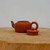 Small handcrafted Yixing teapot in traditional reddish brown zisha clay