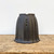 Unglazed dark charcoal grey cascade pot on a weathered wooden tabletop