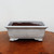 Straight-on view of the glazed Yixing pot on a polished burl table