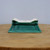 Emerald green glazed rectangular pot on a circular wooden surface