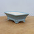 Light blue glazed rectangular pot on a light brown wooden surface