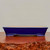 Rectangular cobalt blue glazed pot on a reddish brown wood slab