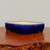 Shallow rectangular blue glazed pot on polished dark reddish wood