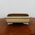 Rectangular cream glazed pot on a rustic dark wood surface