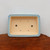 Top-down view of the rectangular sky blue glazed pot on dark wood