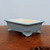 Light blue glazed rectangular pot on dark brown wood
