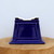 Side view of the cobalt blue glazed pot on a natural wood pedestal