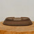 The oval pot tipped up to show its base and foot rails