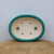 Top-down view of the oval pot's thick teal-green glazed rim