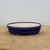High angle side view of the shallow oval dark blue glazed pot