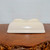 Underside of the cream glazed pot on a polished dark wood surface