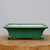 Rectangular green glazed pot on a natural wood cross-section