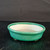 Oval green glazed pot on a dark textured wooden surface