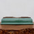 Side profile of the shallow rectangular glazed pot on polished wood