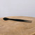 Kaneshin No. 58 arrow pine needle tweezers in a matte finish, on a natural wood surface