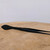 Matte black Kaneshin arrow pine needle tweezers resting horizontally