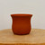 Small unglazed terracotta pot with a curved tapering silhouette