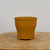 Round unglazed pot in vibrant mustard yellow ochre clay