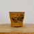 Ochre unglazed ceramic pot on a natural wooden platform
