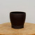 Deep dark brown unglazed pot with a rounded tapering bowl shape