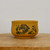 Small round unglazed pot in yellow-toned clay on light wood