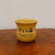 Unglazed ochre ceramic pot on a polished dark brown surface