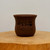 Small unglazed pot with an etched calligraphic design